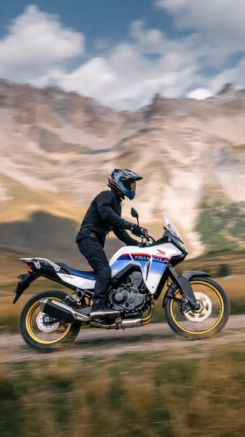 Motocyklista na XL750 Transalp w górskiej scenerii.