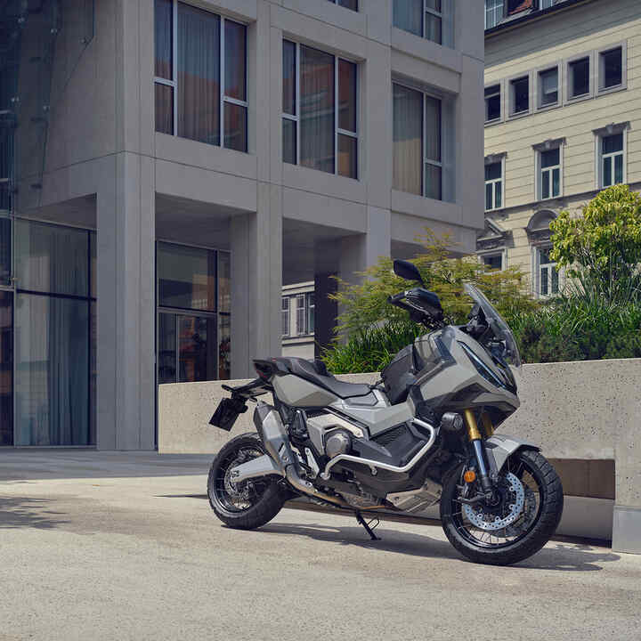 Motocykl X-ADV zaparkowany na podjeździe w mieście.
