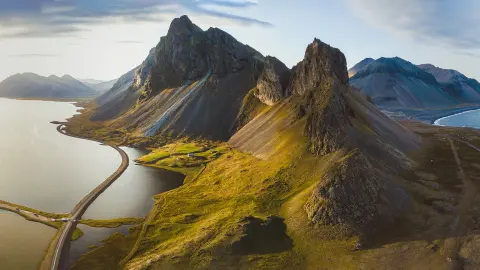 Malownicza droga na Islandii, przepiękne krajobrazy z lotu ptaka, góry i wybrzeże o zachodzie słońca