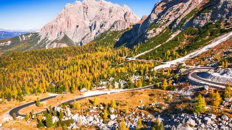 Przełęcz Valparola, Włochy. Widok na krętą drogę w Tyrolu Południowym, Dolomity. Widok na górę Cima Cunturines (3064 m) z przełęczy Valparola jesienią w pobliżu Cortina d'Ampezzo, prowincja Belluno, Włochy