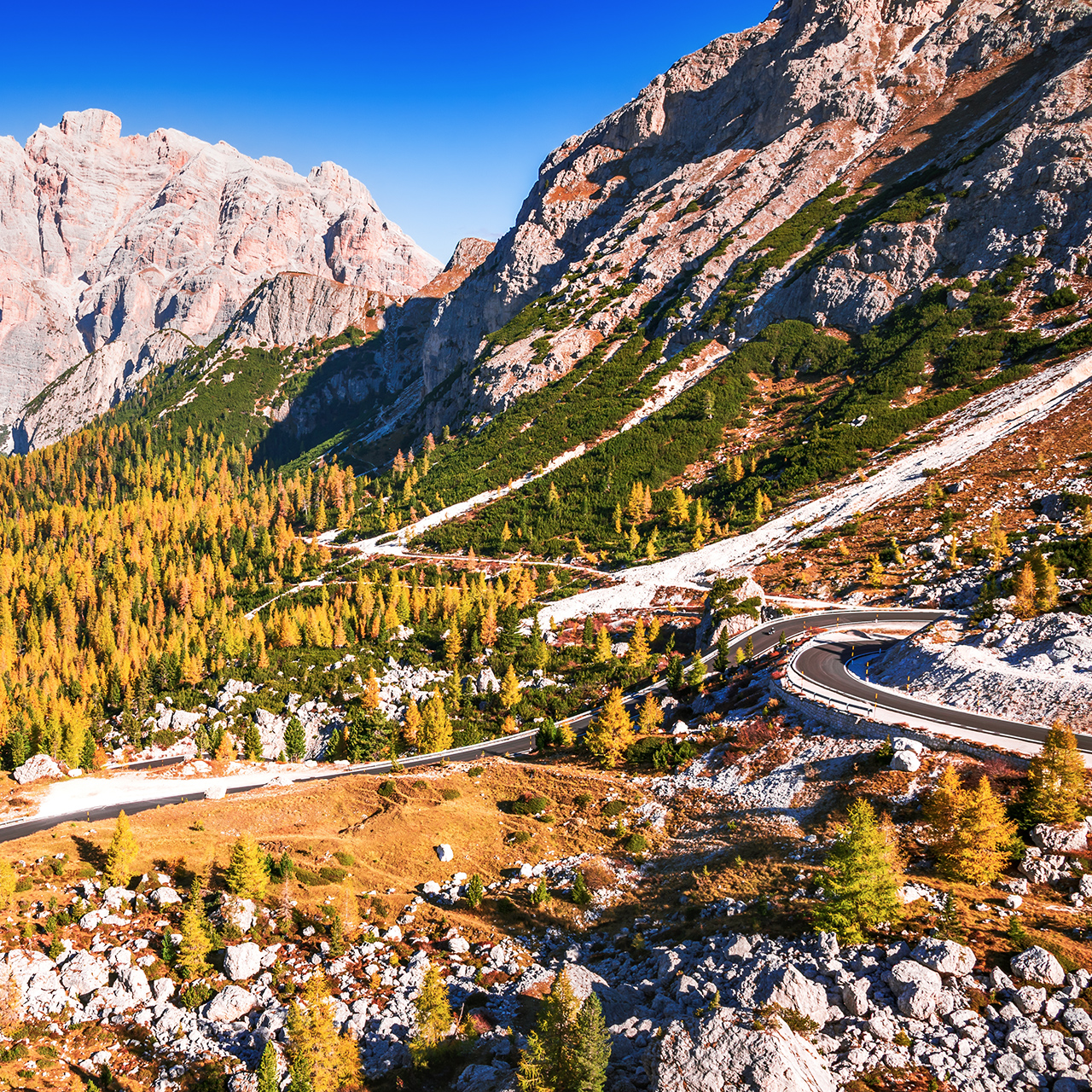 Przełęcz Valparola, Włochy. Widok na krętą drogę w Tyrolu Południowym, Dolomity. Widok na górę Cima Cunturines (3064 m) z przełęczy Valparola jesienią w pobliżu Cortina d'Ampezzo, prowincja Belluno, Włochy