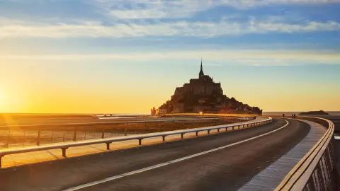 Droga do Mont Saint Michel o zachodzie słońca, Normandia. Francja.