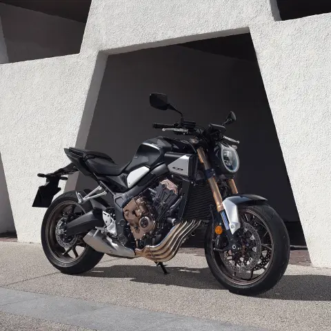 Model na motocyklu w górskiej scenerii.