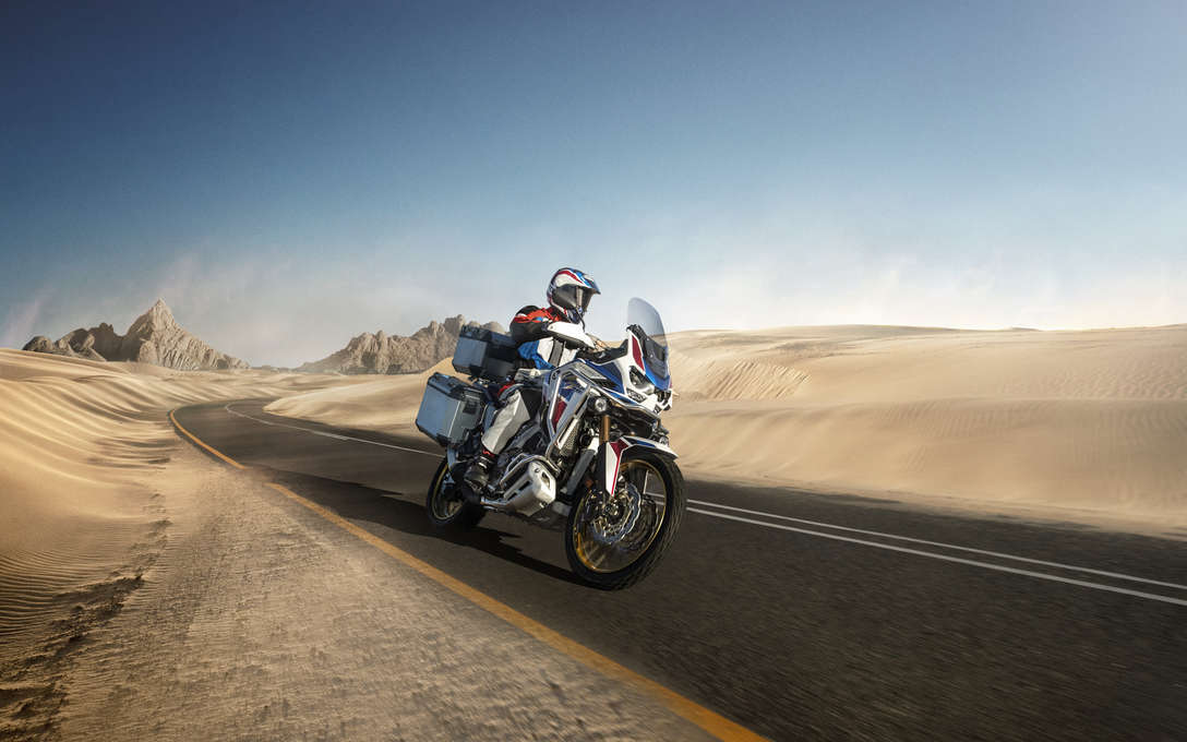 Honda Africa Twin Adventure Sports - widok przedstawiający motocykl w pustynnym otoczeniu z przedniej, prawej perspektywy