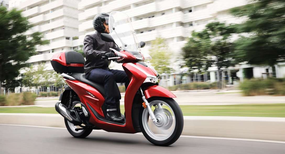 Honda SH125i z kierowcą w mieście – widok z przodu, z prawej strony