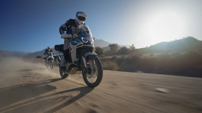 Dwóch kierowców HAR w terenie z górami w tle