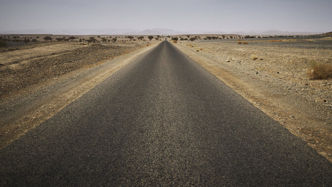 Długa marokańska autostrada otoczona pustynią. 