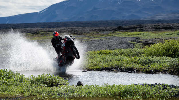 Kiran Mirabet jadący motocyklem Africa Twin przez wodę. 