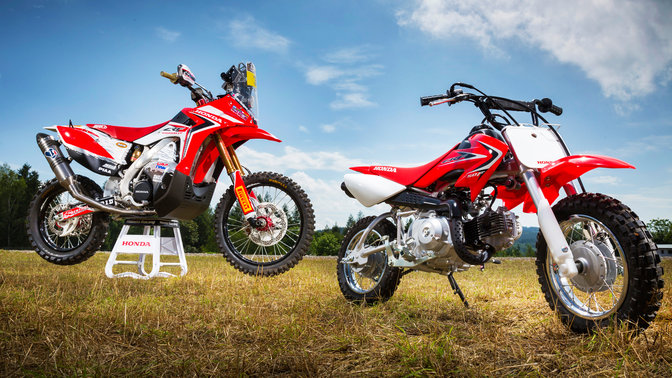 Widok z boku 3/4 na CRF50F, zaparkowaną w plenerze. Widok z prawej strony