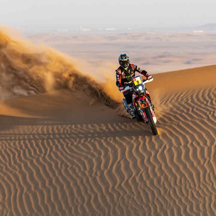 Kierowca Hondy w rajdzie Dakar na pustynnych wydmach. 
