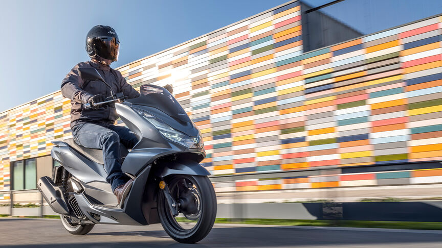 Honda PCX125 - Dynamiczne ujęcie z tyłu z boku z kierowcą na siedzeniu