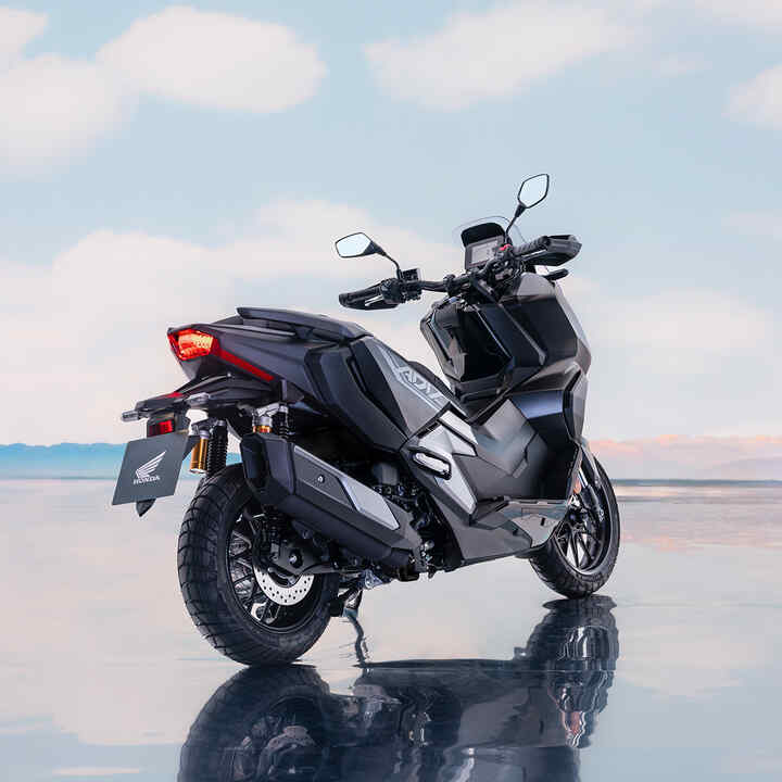 Widok z tył/bok skutera Honda ADV350 w lokalizacji nadmorskiej. 