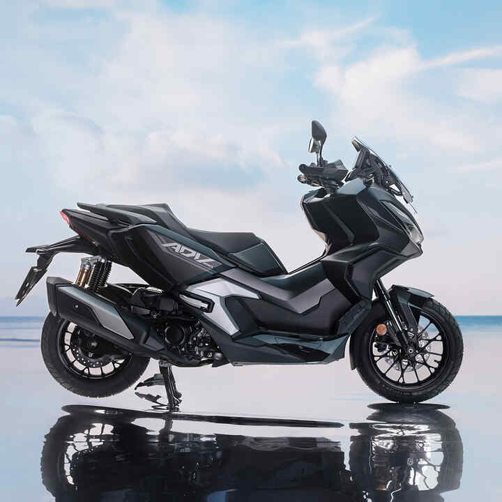 Widok boku Hondy ADV350 w lokalizacji nadmorskiej. 