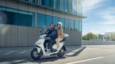 Modele jadący motocyklem Honda CUV e w mieście.