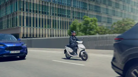 Kierowca prowadzący motocykl Honda CUV e w mieście.