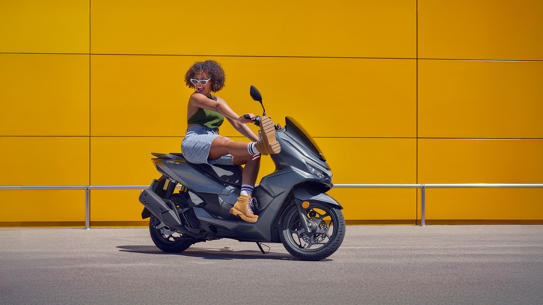 Model siedzący na motocyklu PCX 125.