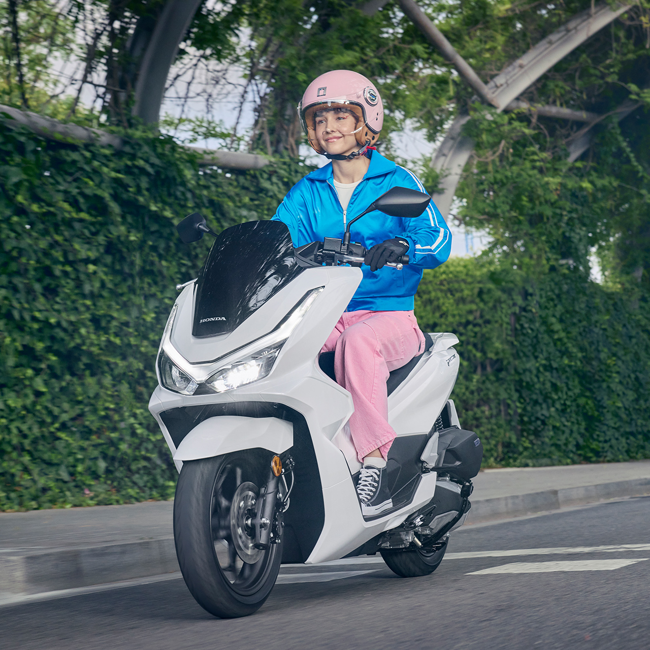 Model jadący motocyklem PCX125 w mieście.