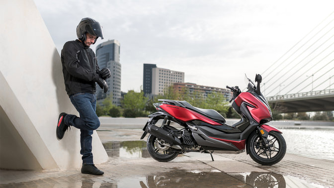 Honda Forza zaparkowana w miejskiej scenerii.