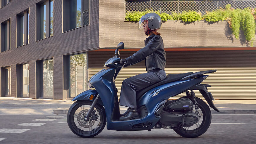 Kobieta jadąca na Hondzie SH350i w mieście.
