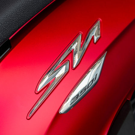 Honda SH350i, zbliżenie na logo SH, czerwony motocykl