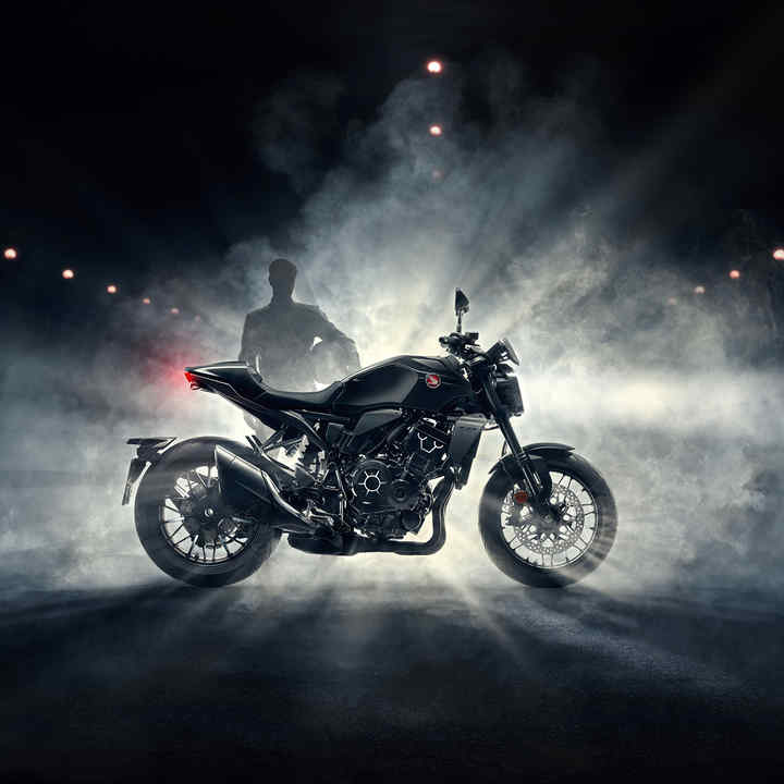 Honda CB1000R - Black Edition - widok z prawej strony, kierowca stojący za motorem we mgle w nocy, czarny motocykl