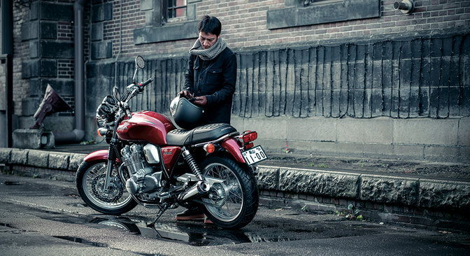 Honda CB1100EX z kierowcą - zdjęcie z tylnej perspektywy.