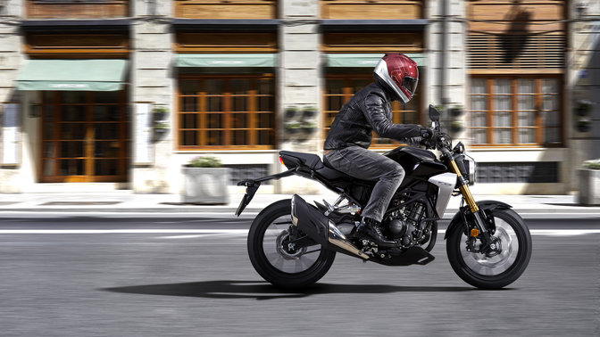 Honda CB300R Neo Sports Café - dynamiczne ujęcie przedstawiające motocykl jadący po drodze.