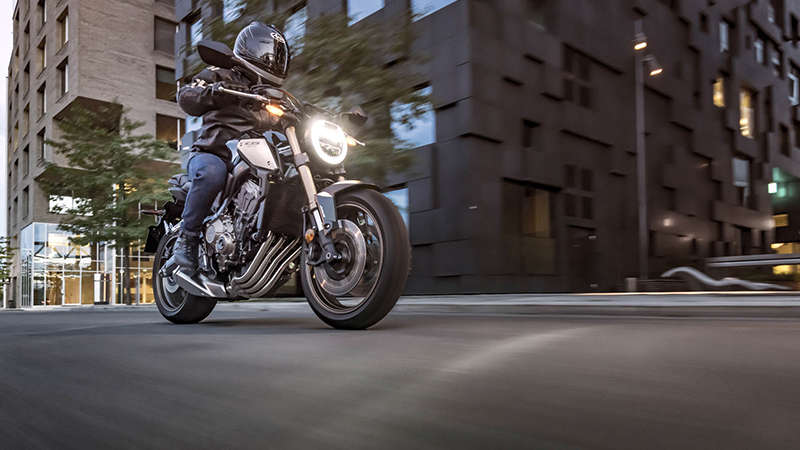 CB650R Neo Sports Café nocą na tle miasta