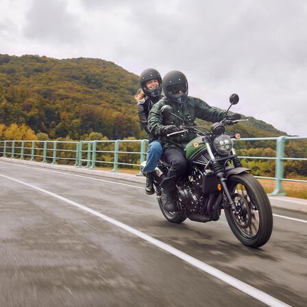 Honda CL500 na drodze z kierowcą i tylnym siodełkiem.