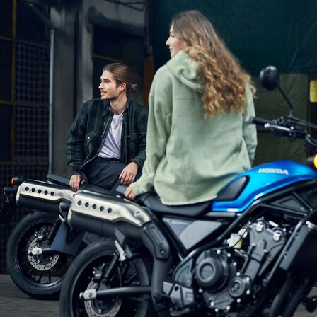 Honda CL500 z modelami siedzącymi na motocyklu.