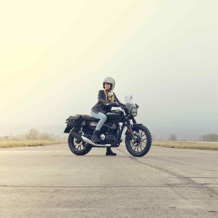 GB350S - zdjęcie z boku na pasie startowym z kobietą na motocyklu