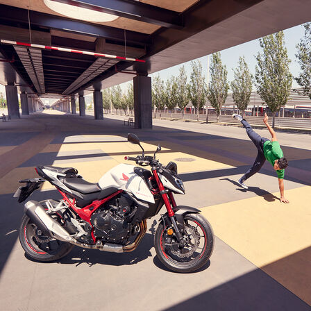 Honda CB750 Hornet pod mostem i człowiek tańczący breakdance.
