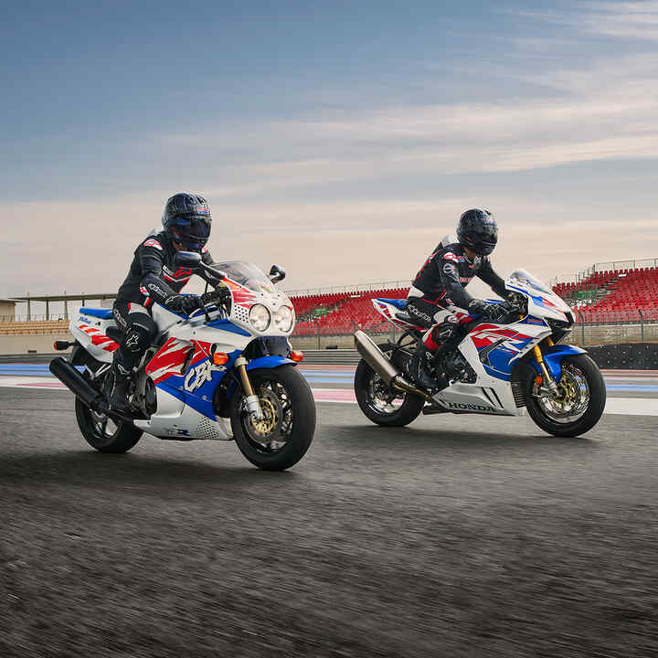 Dwóch motocyklistów stojących obok siebie na Hondach CBR1000RR-R-Fireblade na torze wyścigowym