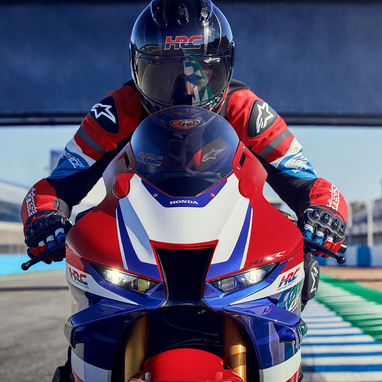 Zbliżenie: kierowca na Hondzie CBR1000rr-r model Fireblade na torze, widoczny od przodu. 