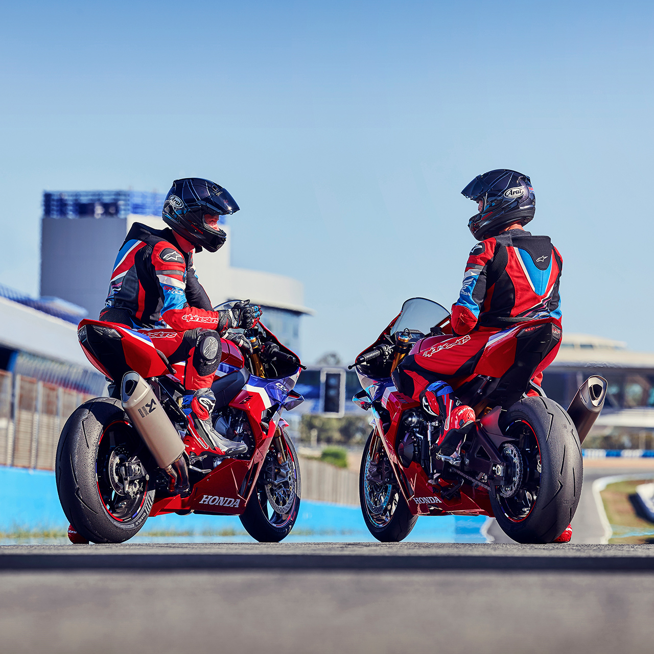 Widok z tyłu na dwóch motocyklistów na Hondzie CBR1000rr-r Fireblade na torze. 