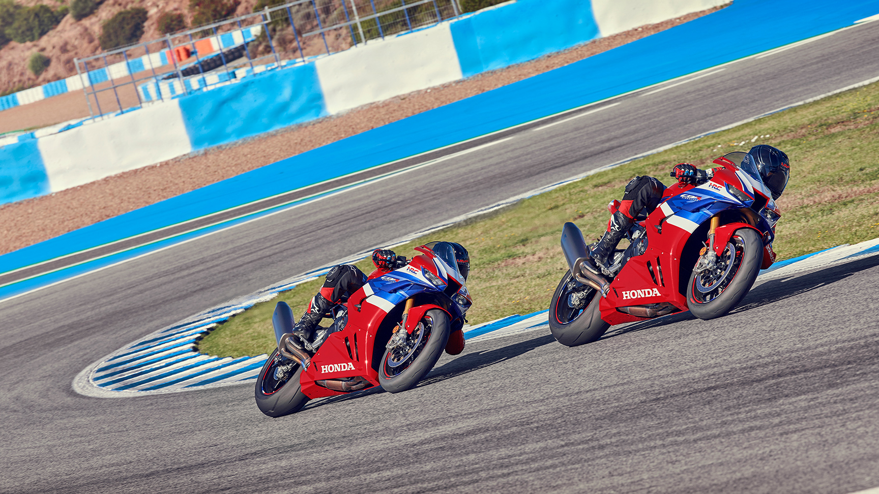Dwóch motocyklistów na Hondzie CBR1000RR-R Fireblade na torze, w połowie zakrętu