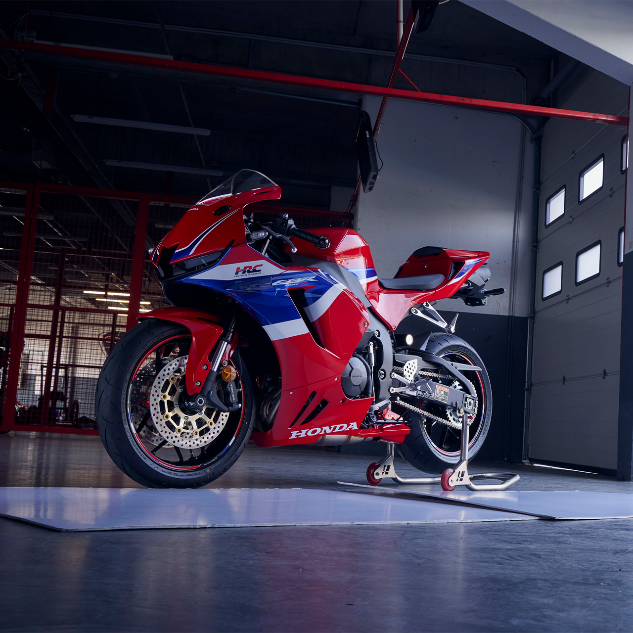 CBR600RR - ujęcie statyczne z przodu z boku na motocykl stojący w garażu na torze wyścigowym.