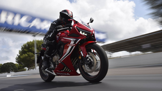 Zdjęcie motocyklisty pędzącego po torze wyścigowym motocyklem CBR650R