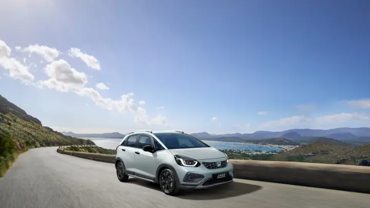 Front facing Honda Jazz Hybrid driving under a bridge. 